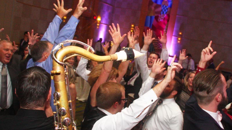 Close up as a tenor saxophone makes its way through the crowded dance floor at a recent Retrospect Band wedding in Bethesda