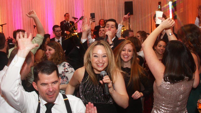 Retrospect Band's vocalists Tara and Mike making their way onto a crowded dance floor at a recent country club wedding in Rockville MD